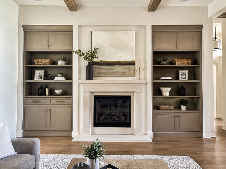 Painted built-in cabinets flanking a fireplace with open shelving above closed storage