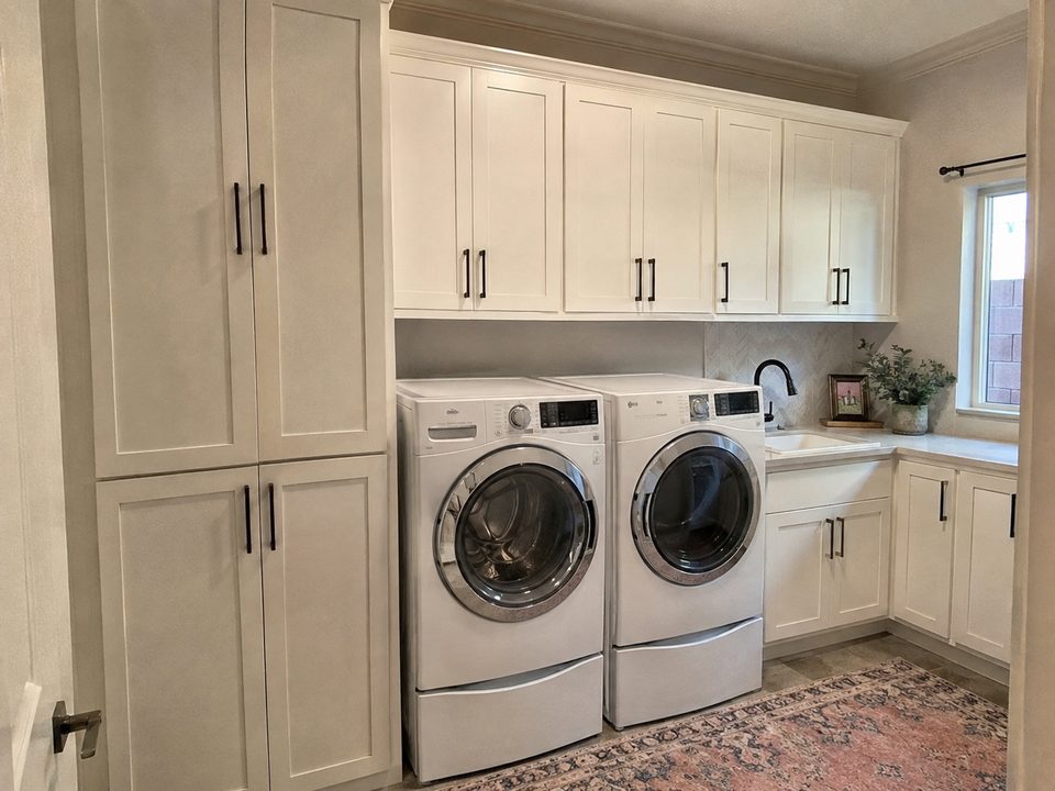 Laundry room cabinets with tall storage and upper cabinets above the washer and dryer